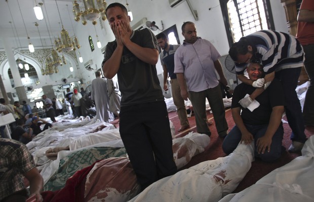 Homem se desespera ao ver corpo de parente estendido no chão de mesquita no Cairo, capital do Egito.  Na quarta-feira (14), operação policial para dispersar manifestantes partidários do presidente deposto Mohamed Morsi de acampamentos mataram pelo menos 5 (Foto: AP Photo/Khalil Hamra)