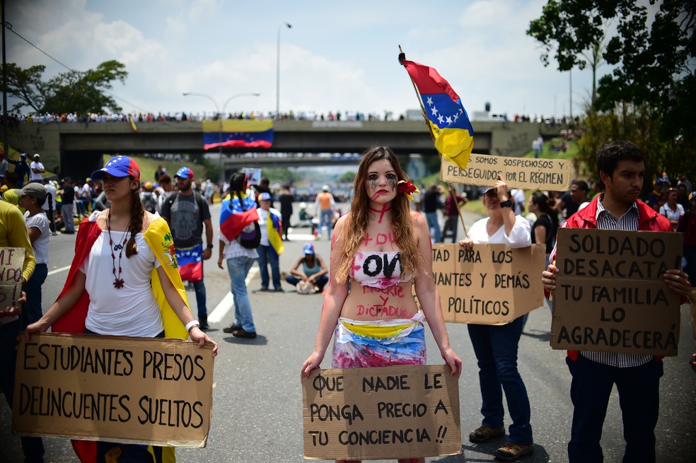 Manifestantes contra o governo de Nicolás Maduro ocupam avenida Francisco Fajardo nesta segunda-feira (24) em Caracas (Foto: RONALDO SCHEMIDT / AFP)