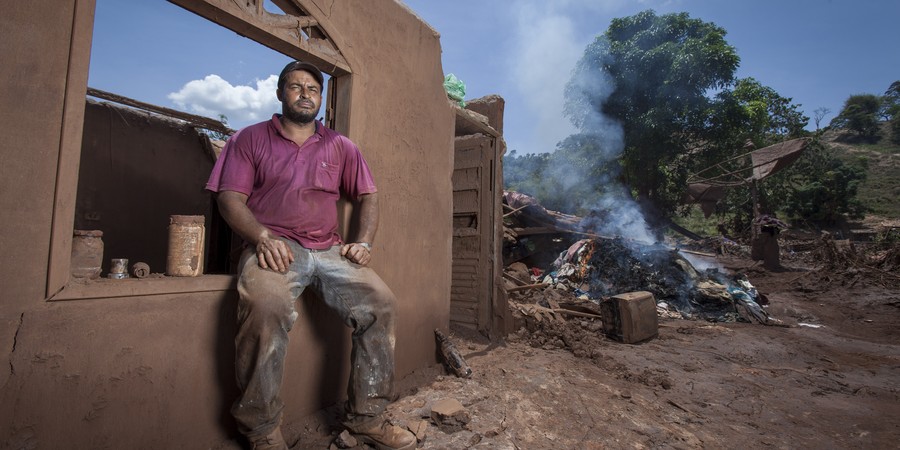 Distrito de Mariana, Paracatu de Baixo,Loral Goncalves Marcelino (agachado), 42 anos, em frente a sua casa que foi destruida.  (Foto: ALEXANDRE C. MOTA/Nitro/ÉPOCA)