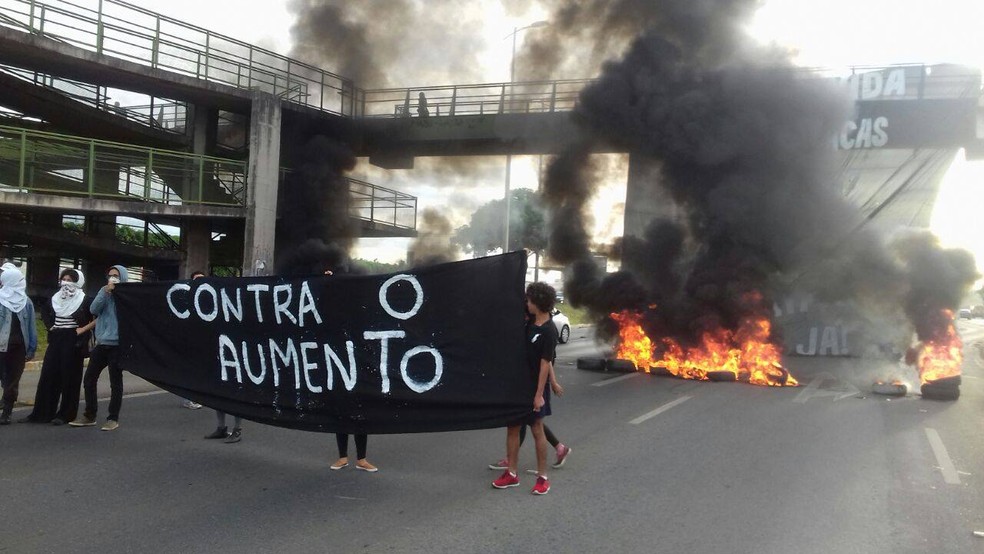 Manifestantes ligados ao Movimento Passe Livre erguem faixa na EPTG; ao fundo, pneus são queimados (Foto: Movimento Passe Livre/Divulgação)
