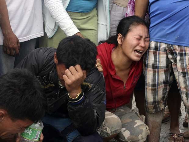 Filipinos choram a morte de parentes em Nova Bataan, no sul do país. (Foto: Karlos Manlupig / AP Photo)