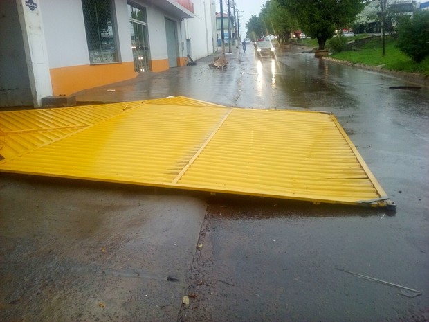 Portão de loja que caiu na marginal da BR-364 (Foto: Rogério Aderbal/ G1)