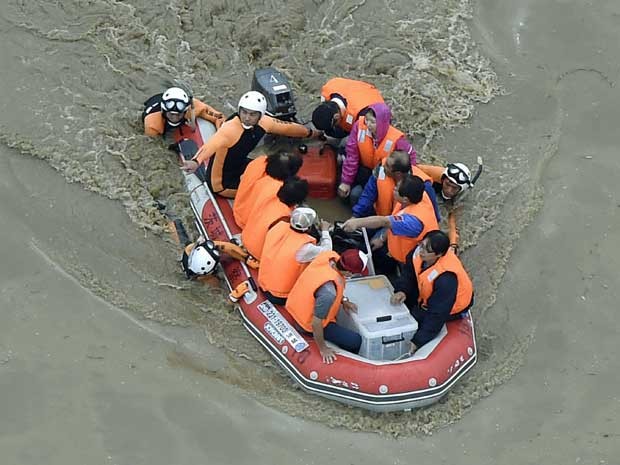 Moradores são resgatados por barco em Joso (Foto: Kyodo News / via AP Photo)