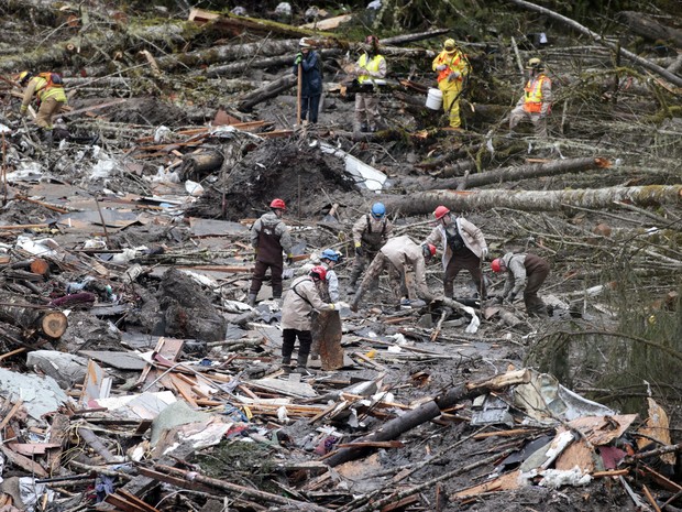 Trabalhadores vasculham escombros no local do deslizamento de em Oso, Washington. Além dos 26 corpos já encontrados, dezenas poderiam estar soterradas (Foto: Lindsey Wasson/AP)