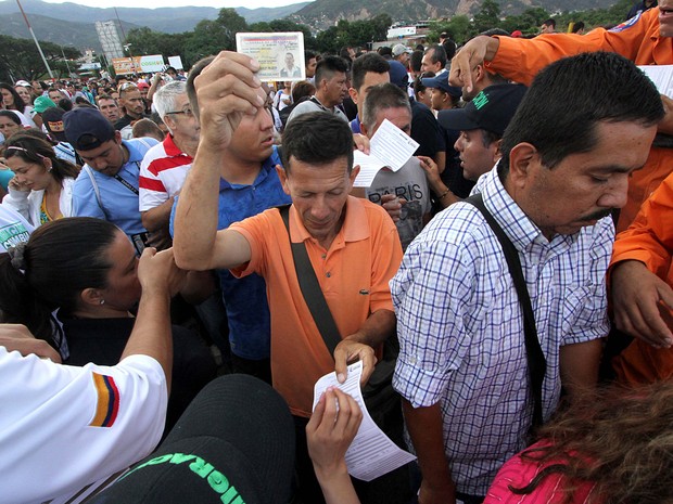  Venezuelanos mostram documentos ao cruzar fronteira com Colômbia  (Foto: George Castellanos/AFP)