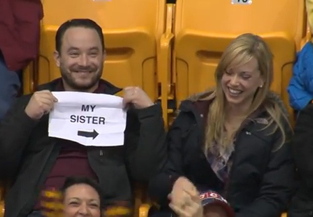 Homem tirou folha do bolso com os dizeres 'minha irmã' ao ser focalizado pela 'câmera do beijo' em jogo de basquete universitário nos EUA (Foto: Reprodução/YouTube/Minnesota Gophers) Homem tirou folha do bolso com os dizeres 'minha irmã' ao ser focalizado pela 'câmera do beijo' em jogo de basquete universitário nos EUA (Foto: Reprodução/YouTube/Minnesota Gophers)