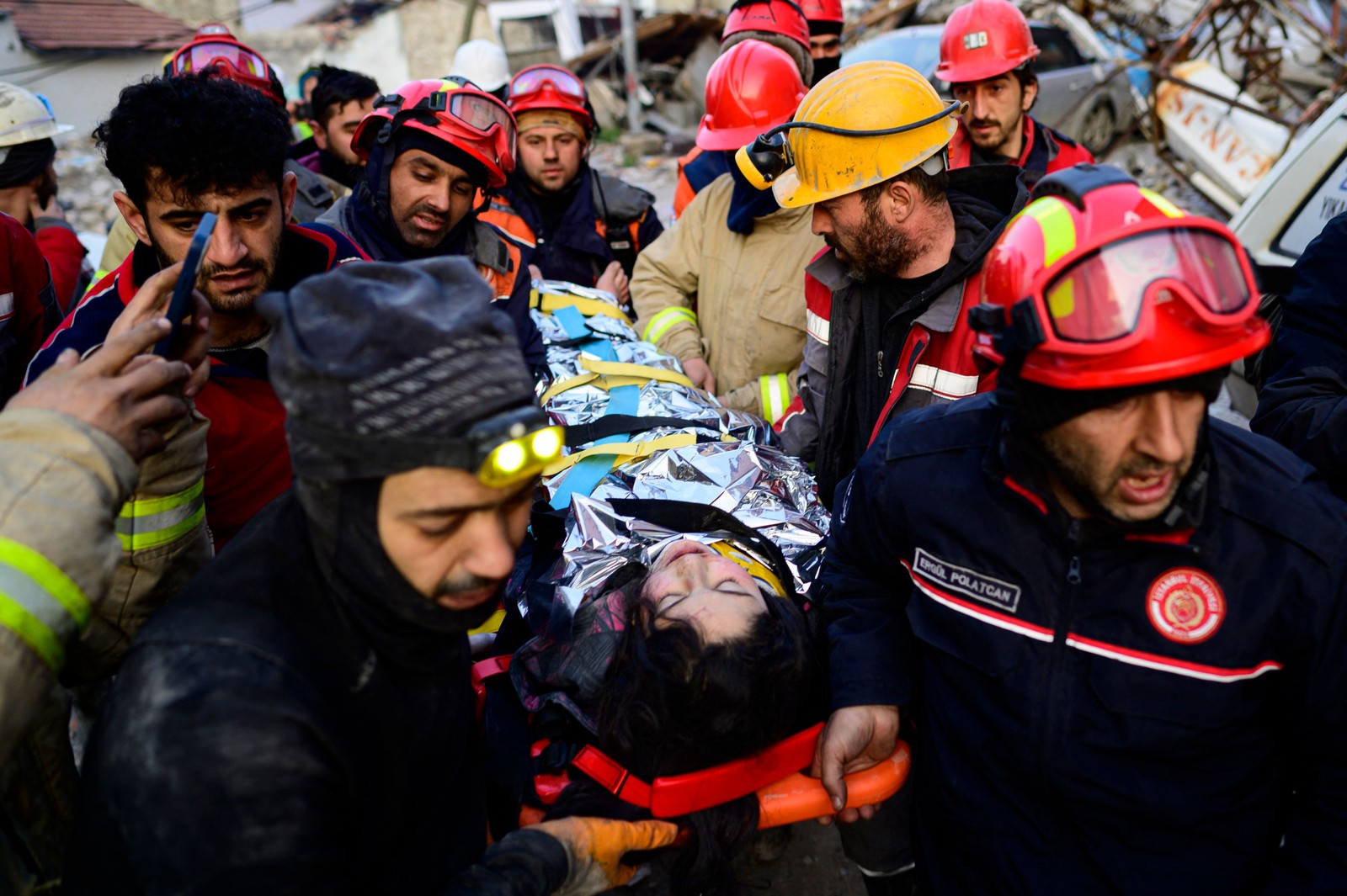 Equipes de resgate evacuam uma menina síria de 12 anos, Cudi, dos escombros de um prédio destruído em Hatay — Foto: YASIN AKGUL/AFP