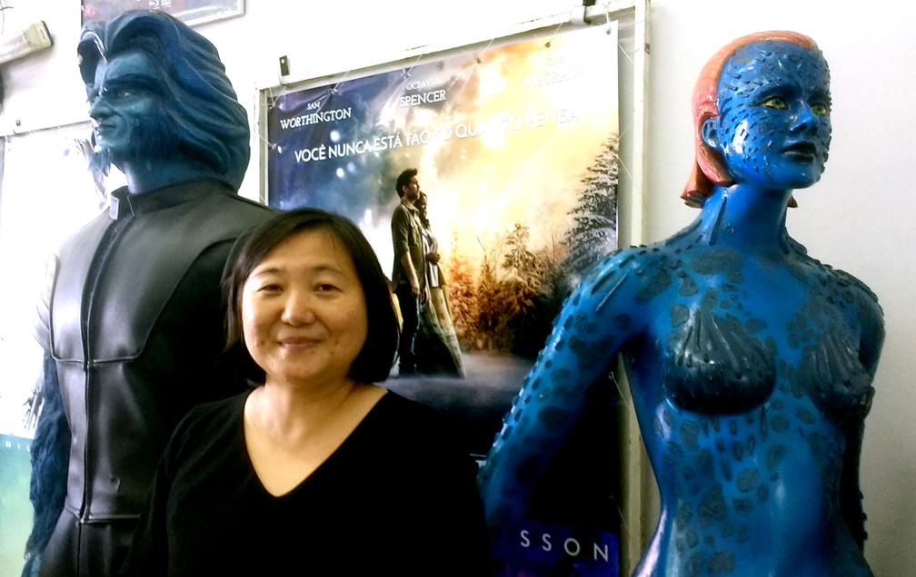 Cristina Shibukawa ao lado de bonecos promocionais da série 