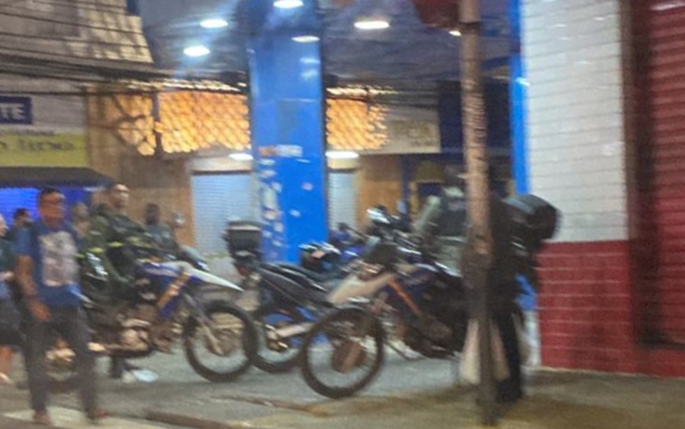 PMs em frente a farmácia onde vigilante foi atingido por tiros durante assalto — Foto: Reprodução/WhatsApp