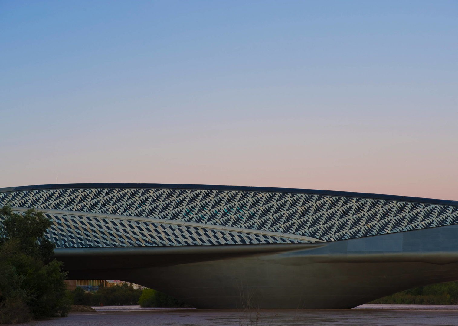 Zaragoza Bridge Pavilion, Zaragoza, Espanha, projetado por Zaha Hadid.  O exterior da construção é composto por 29.000 triângulos de concreto reforçado com fibra de vidro (Foto: Reprodução / zaha-hadid.com)