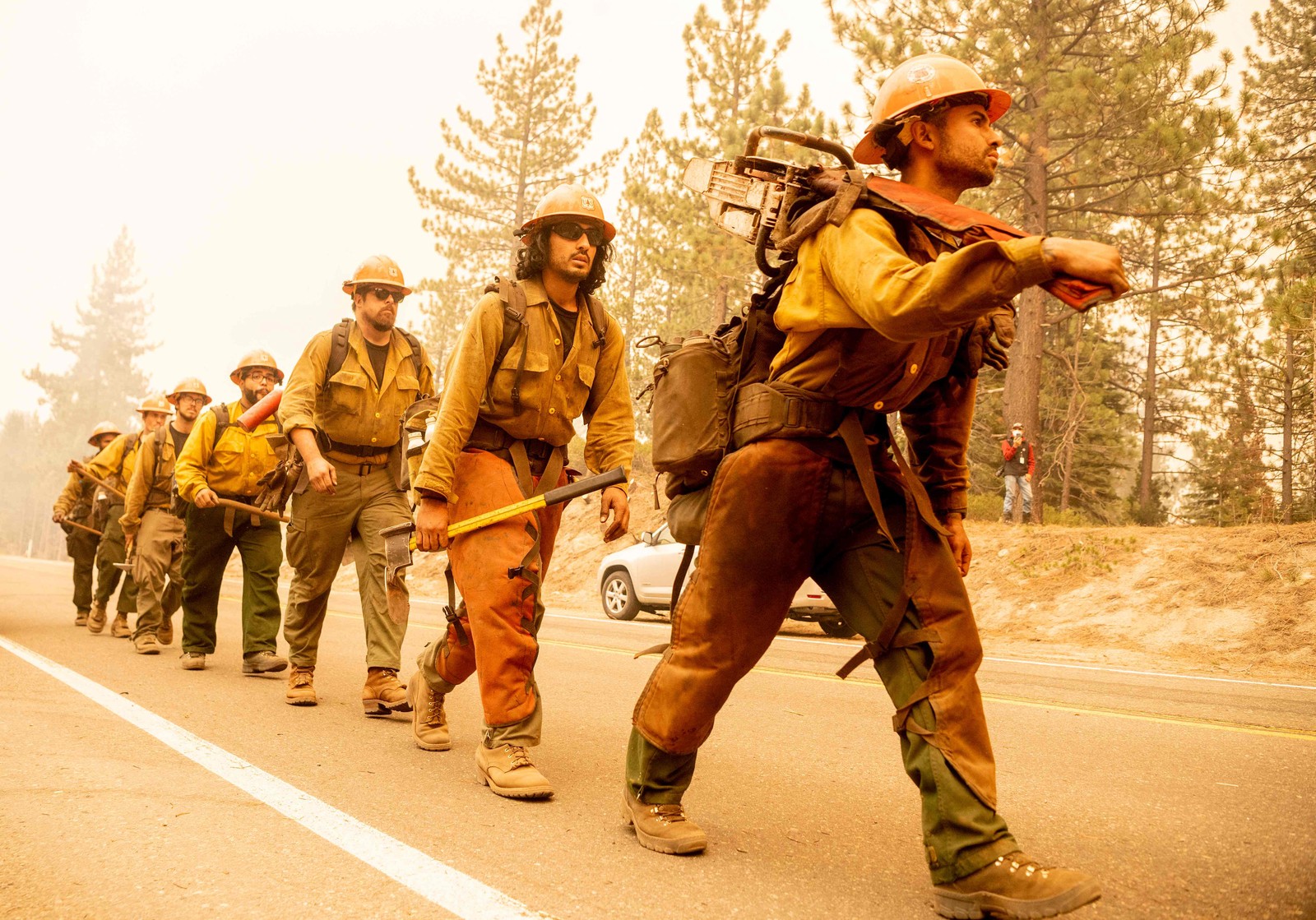 Equipe de bombeiros do Serviço Florestal dos EUA chega ao local onde as chamas do incêndio ameaçam atravessar a rodovia 50 em Meyers, Califórnia, onde milhares de pessoas receberam ordens de deixar suas casasAFP
