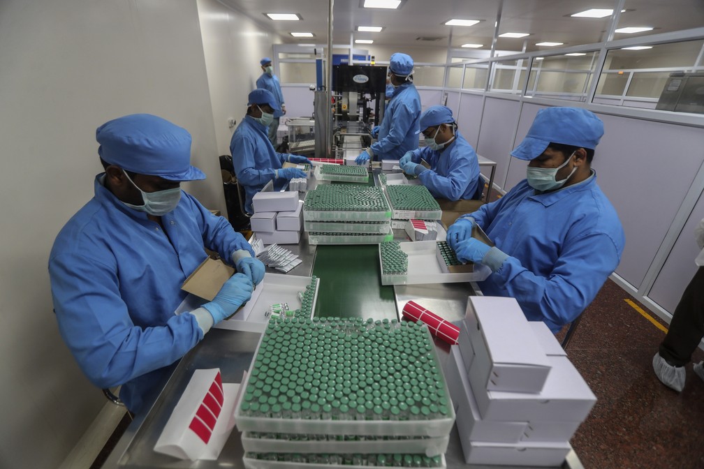 Na foto, de 21 de janeiro de 2021, funcionários embalam caixas contendo frascos de Covishield, versão da vacina AstraZeneca/Oxford produzida na Índia, no Instituto Serum, na cidade de Pune.  — Foto: Rafiq Maqbool/AP