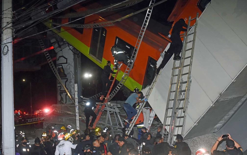 Bombeiros e equipes de resgate trabalham para retirar vítimas de vagão que caiu depois que um trecho da Linha 12 do metrô desabou na Cidade do México — Foto: Jose Ruiz/AP