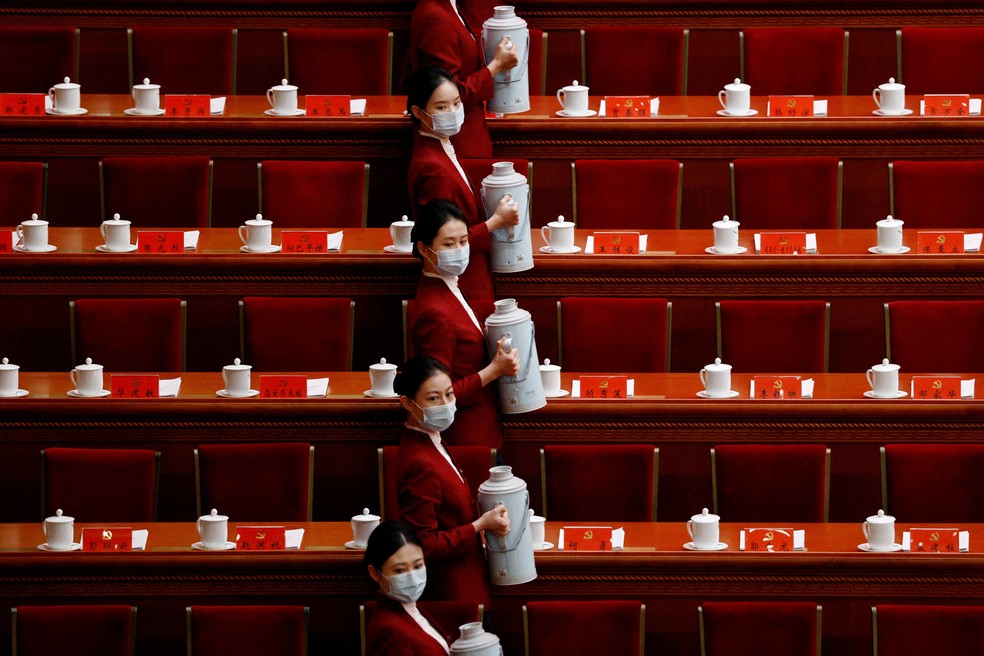 Mulheres carregam garrafas de chá pouco antes da abertura do 20º Congresso do Partido Comunista da China — Foto: Thomas Peter/ Reuters