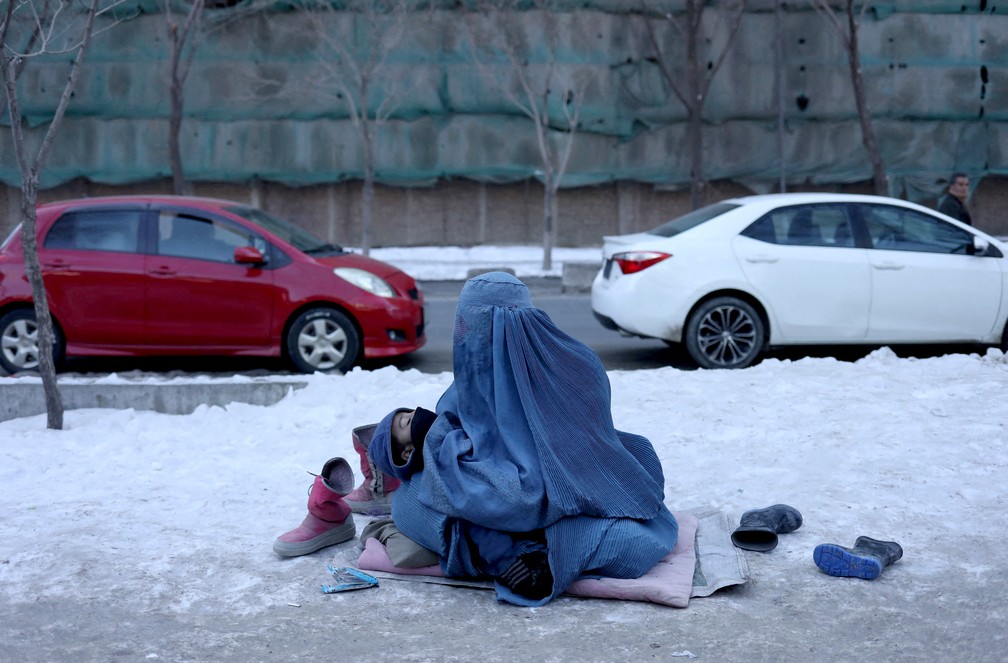 27 de janeiro - Mulher afeg em situao de vulnerabilidade segura seu filho em uma calada coberta de neve em Cabul, Afeganisto — Foto: Ali Khara/Reuters