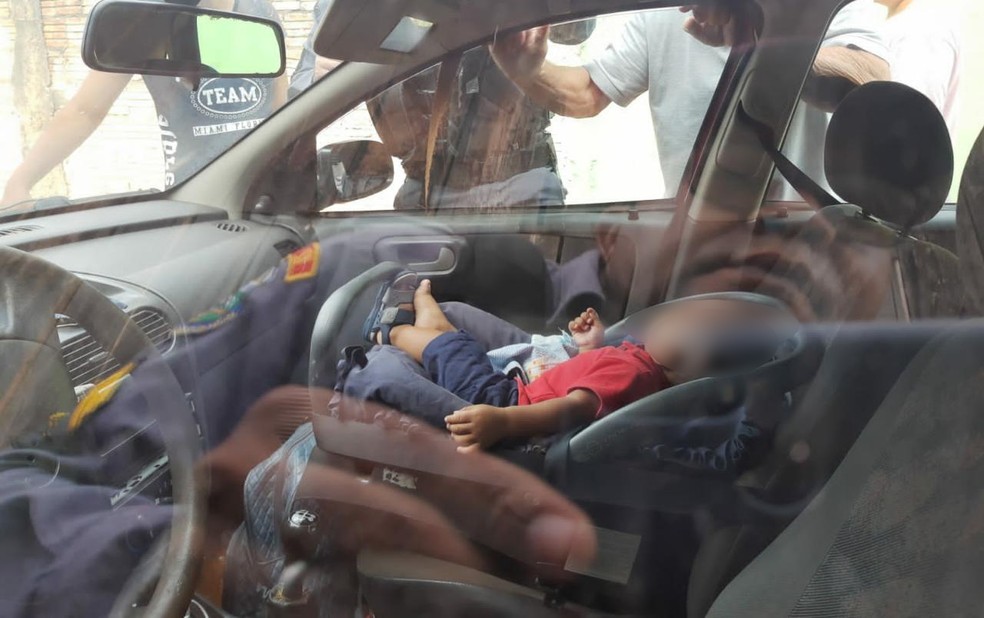 Bebê foi resgatado por policiais sem sinal de lesão após ficar trancado em carro em casa — Foto: Polícia Militar/Divulgação