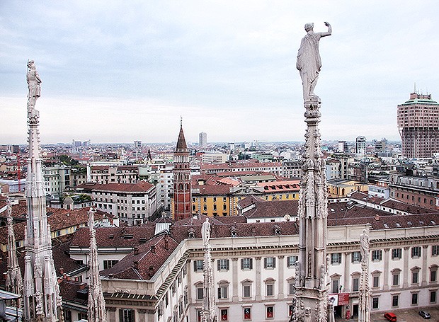 Figuras sacras e gárgulas no topo do Duomo, a catedral de Milão, coma Torre Velasca à direita (Foto: Marcia Evangelista/Editora Globo)