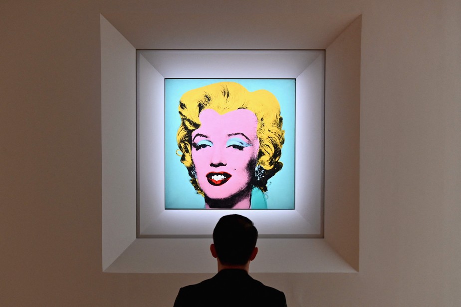 Um homem olha para 'Shot Sage Blue Marilyn' de Andy Warhol durante a pré-visualização na Christie's, em Nova York: US$ 8,4 bi em vendas em 2022
