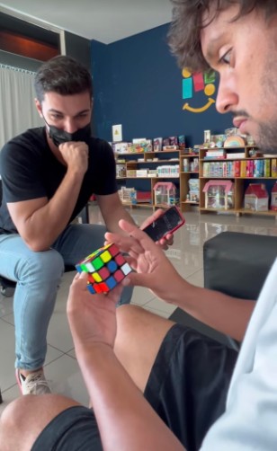 Gustavo Scarpa resolvendo um cubo mágico ao lado de Renan Cerpe, especialista no assunto (Foto: Reprodução / Instagram)