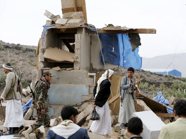 Militantes rebeldes houthi são vistos nos escombros de uma casa destruída por bombardeio da Arábia Saudita em Sanaa, no Iêmen, na quarta (26) (Foto: Reuters/Khaled Abdullah)