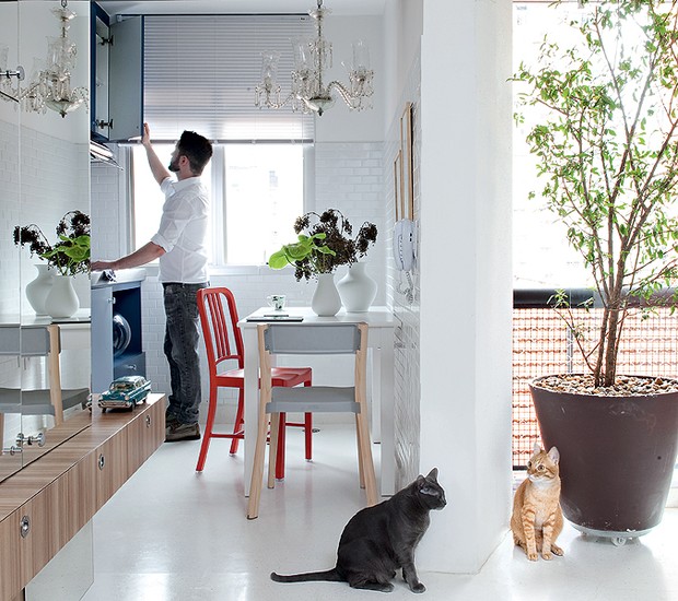 A cozinha minúscula do apartamento de 42 m² tem uma pequena mesa e duas cadeiras diferentes. Coloridas, elas trazem alegria para o ambiente branco (Foto: Marcelo Magnani/Casa e Jardim)