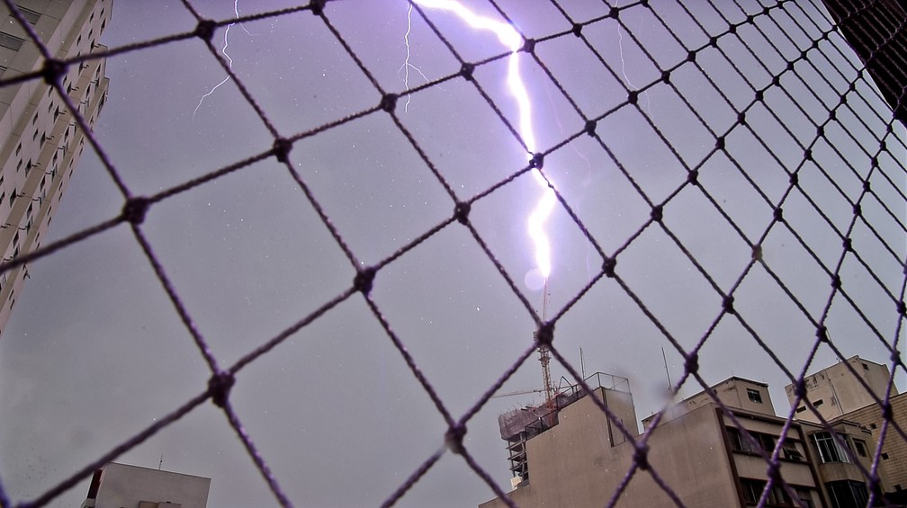 1º de dezembro - Raio atinge o topo de uma grua de prédio em obra em frente ao Largo da Batata, em Pinheiros, Zona Oeste de São Paulo, no início de um temporal com granizo que derrubou árvores pela cidade. Uma motorista morreu após ter o carro atingido por uma árvore — Foto: Fábio Tito/G1