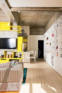 A arquiteta Letícia Arcangeli, da marcenaria Santíssima Fé, criou e executou os módulos laqueados amarelos que pontuam o pilar no qual fica a TV