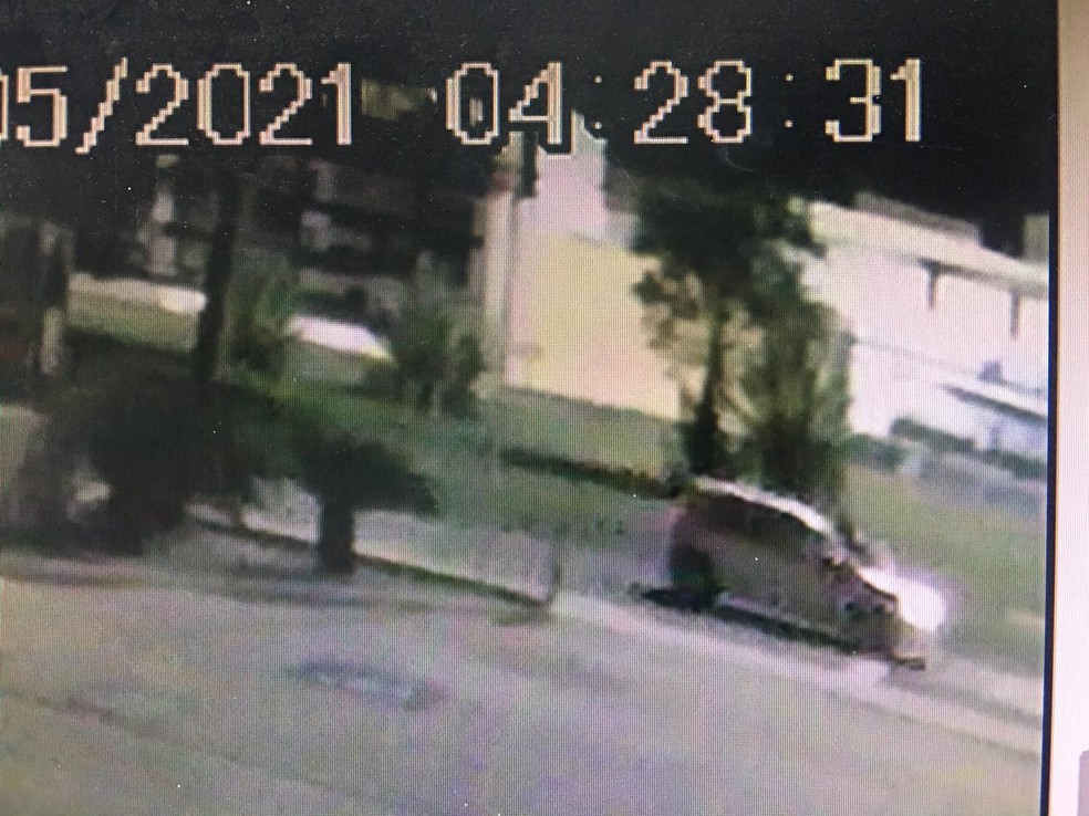 Imagens de câmera de segurança mostram uma pessoa no capô do carro — Foto: Divulgação/Polícia Civil