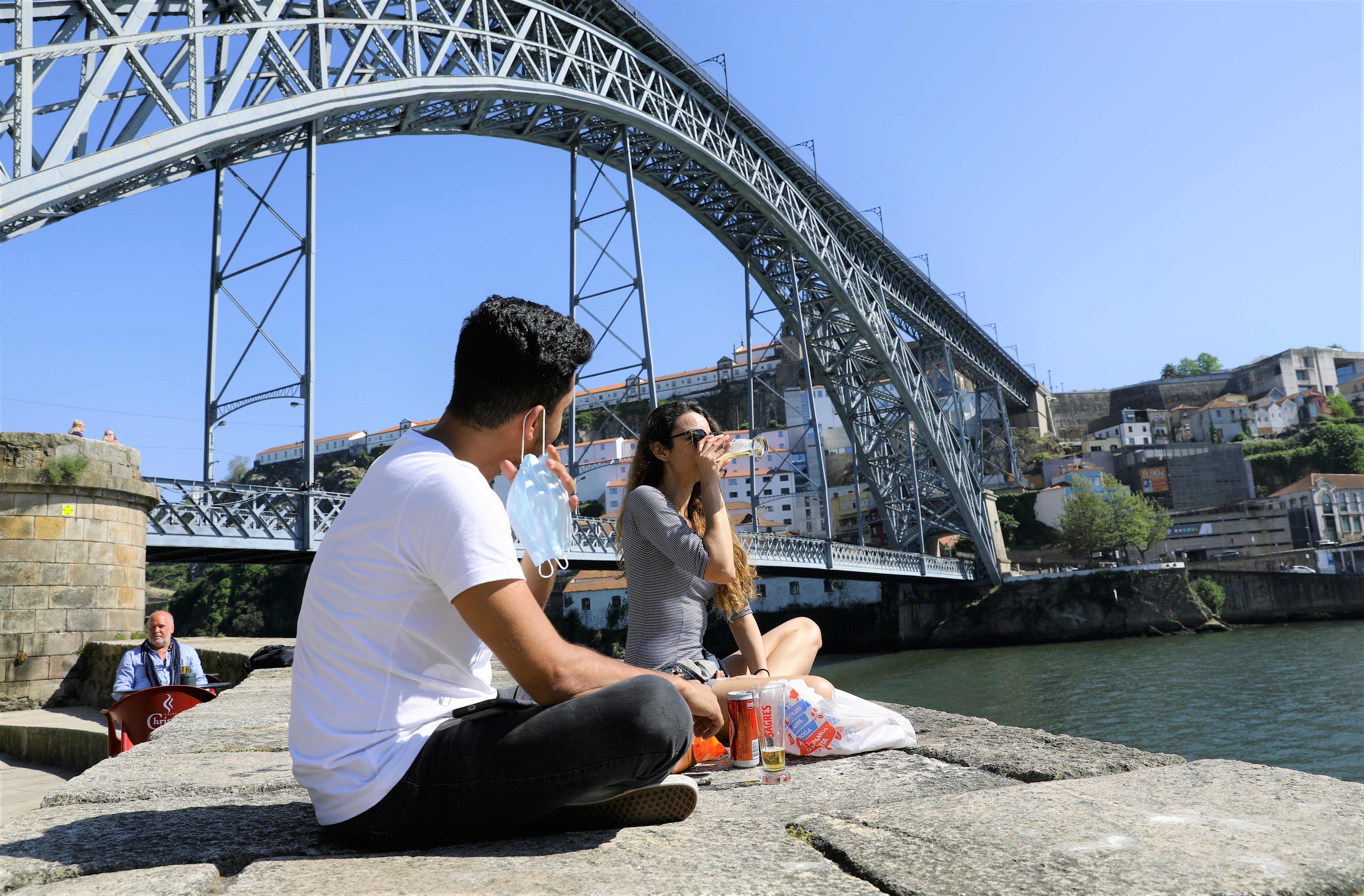 Dupla bebe cerveja à beira do Rio Douro, no Porto, Portugal