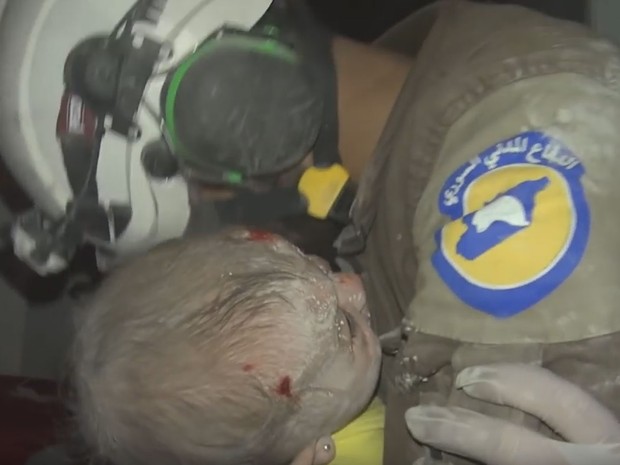 O sírio Abu-Kifah, do grupo Capacetes Brancos, chora após ajudar a resgatar bebê em escombros de bombardeio em Idlib, na quinta (29) (Foto: Reprodução/Youtube/معاذ الشامي)