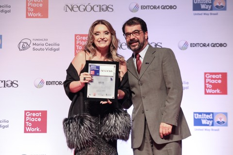Marcia Mocelin Manfrin, presidente da Apetit Serviços de Alimentação, recebe o prêmio de Carlos Raíces, da Editora Globo