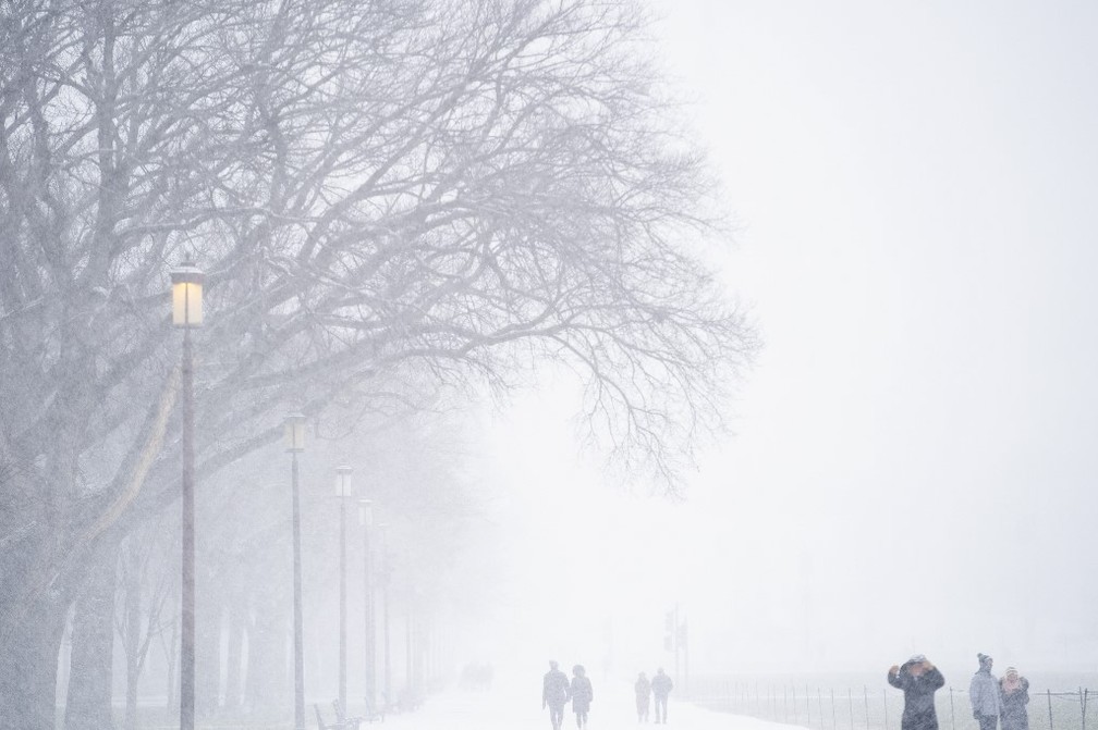 Pessoas caminham no National Mall, em Washington, D.C., durante tempestade de inverno — Foto: Stefani Reynolds/AFP