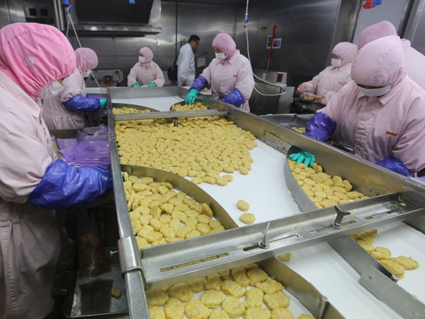 Foto feita neste domindgo (20) mostra produção de trabalhadores na Shanghai Husi Food Co, fábrica do OSI Group, em Xangai (Foto: AFP)