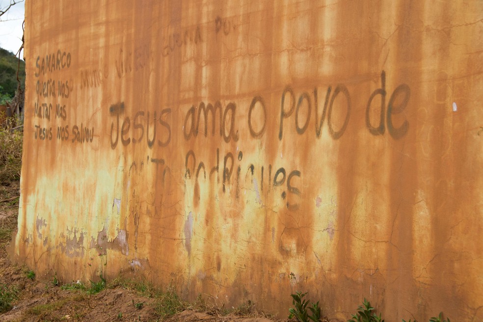 A parede estampa a expressão de fé de ex-moradores do distrito. — Foto: Leonardo Miranda/TV Globo