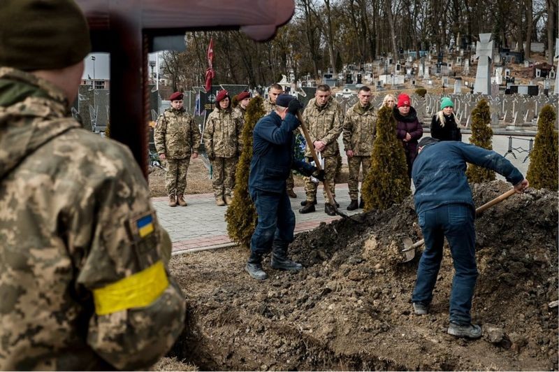 Coveiros do cemitério Lychakiv cobrem o caixão de Kotenko com terra (Foto: BBC News)