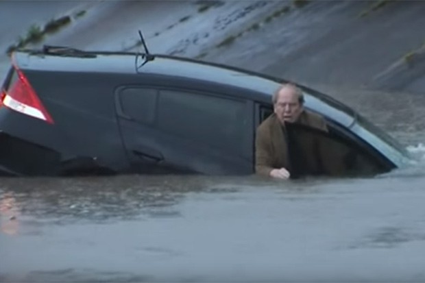 Repórter ajuda motorista pego por enchente (Foto: Reprodução)