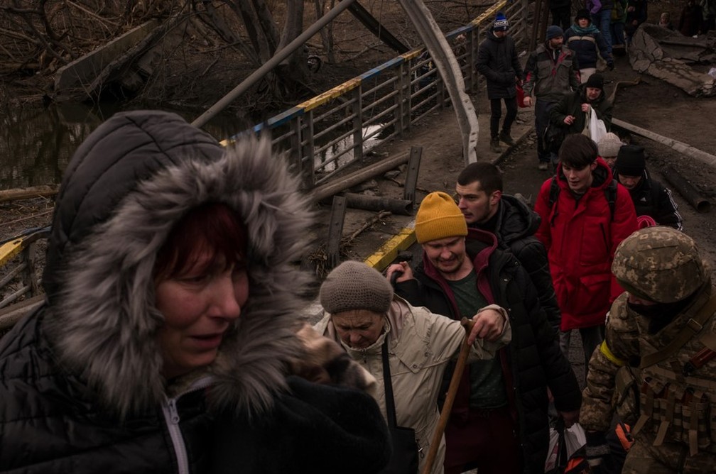 Moradores andam sobre ruínas de ponte para chegar a Kiev — Foto: Gabriel Chaim/g1