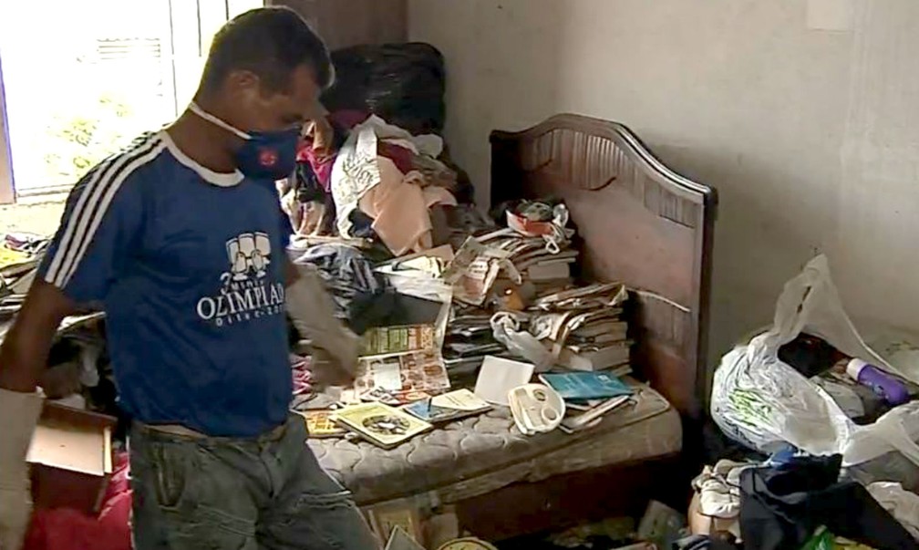 Funcionário da prefeitura protegido com luvas e máscaras: material está todo contaminado pela urina de ratos  — Foto: TV TEM/Reprodução