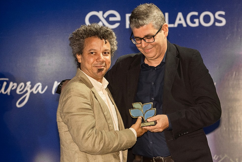 Marcos Homem recebe o troféu de primeiro lugar em Fotojornalismo do Gerente de Operações de Esgoto, Mário Márcio Gonçalves — Foto: Divulgação Prolagos