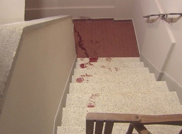 Sangue do rapaz ficou nas escadas do prédio (Foto: Reprodução/TV Tribuna)