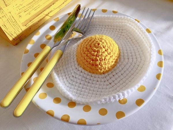 Prato de poá amarelo com ovo de crochê compôs a decoração da mesa do bolo (Foto: Arquivo Pessoal)