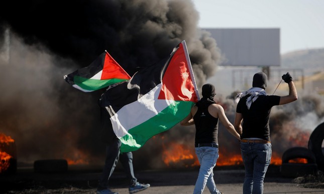Manifestantes palestinos em frente a incêndio perto de Nablus na Cisjordânia ocupada