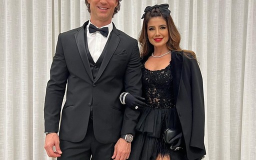 Paula Fernandes usa vestido fendado e luvas para festa com o namorado