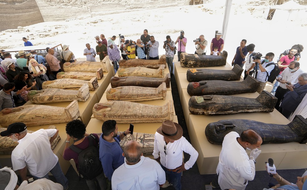 Arqueólogos e jornalistas observam sarcófagos encontrados em Saqqara, no Egito, em 30 de maio de 2022.  — Foto: Associated Press