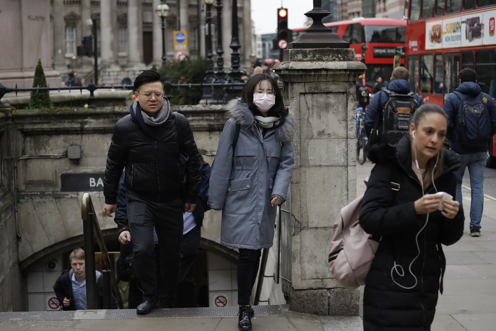 Uma mulher com uma máscara protetora é vista saindo do metrô de Londres, no Reino Unido, em 4 de março. A feira do livro da cidade foi cancelada por causa do Covid-19, doença causada pelo novo coronavírus. — Foto: Matt Dunham/AP