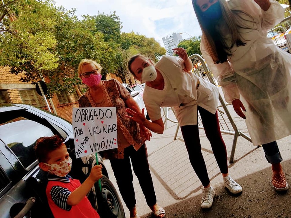 Neto comemora ao lado da avó com equipe que a vacinou contra Covid em Caxias do Sul — Foto: Rubia Rossi/Arquivo Pessoal