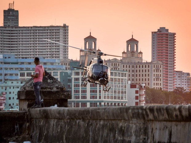 Moradores de Havana observam um helicóptero sobrevoando a cidade durante gravações do filme 'Velizes e Furiosos 8' em Cuba (Foto: Adalberto Roque/AFP)