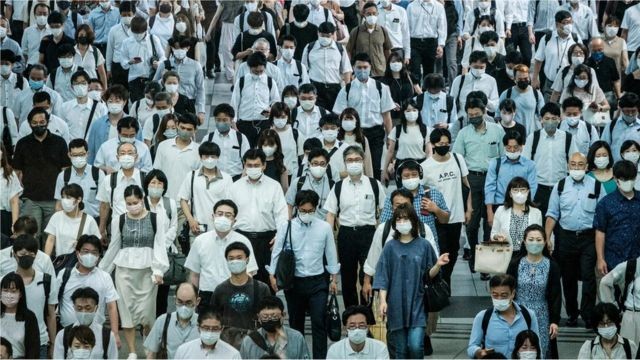Multidão de passageiros de trem usando máscaras em Tóquio, no Japão (Foto: YASUYOSHI CHIBA/AFP/GETTY IMAGES via BBC)