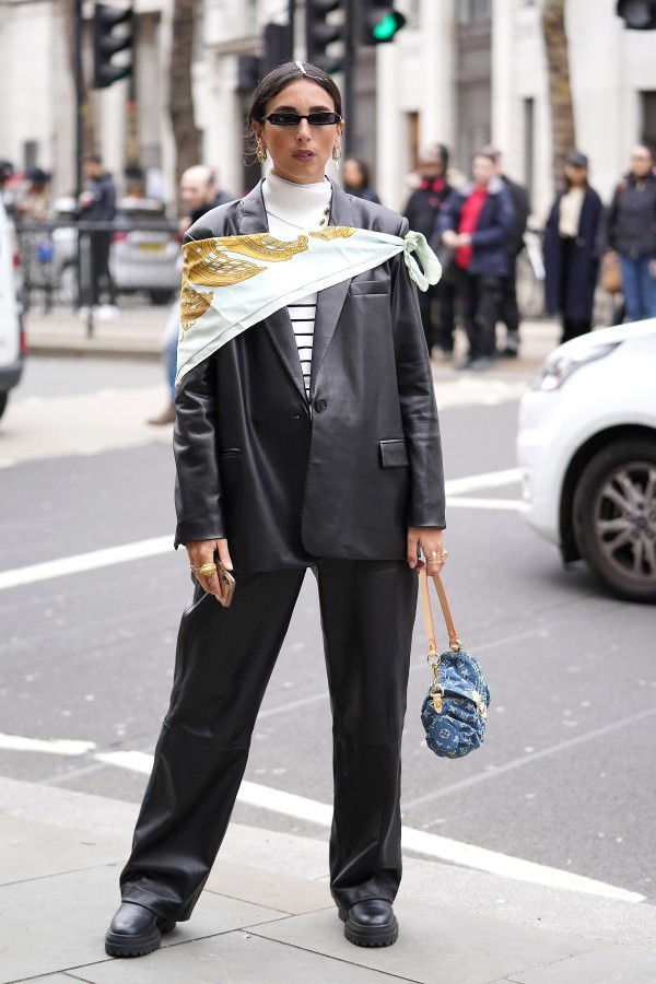LONDON, ENGLAND - FEBRUARY 14: Gabriella Berdugo wears black leather jacket and trousers with printed scarf and Louis Vuitton purse during London Fashion Week February 2020 on February 14, 2020 in London, England. (Photo by Neil Mockford/Getty Images) (Foto: Getty Images)