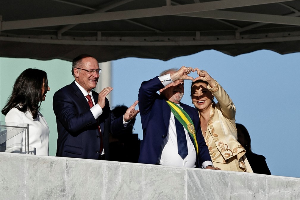 Lula e Janja fazem um coração com as mãos para a multidão — Foto: REUTERS/Ueslei Marcelino